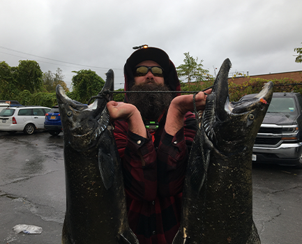Sean holding two 20lb Salmon.